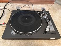 Full top view of the Toshiba DC Servo Turntable with dust cover open showing platter, tonearm, and control buttons.