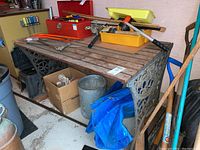 Front view of full table showing wood slatted top and decorative wrought iron base