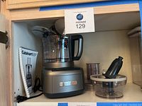 Overall view of Cuisinart food processor base unit with large bowl, small bowl, pusher, and power cord.