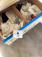 Drawer containing folded gloves and handkerchiefs laid out showing variety of colors and some floral designs.
