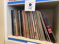 Shelf with various vinyl LP records showing many classical music albums and an opera book at the end