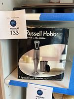 Box packaging of Russell Hobbs 3 speed hand blender showing product image and branding.