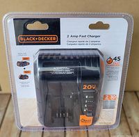 Front view of BLACK+DECKER 20V MAX lithium battery charger in original sealed packaging showing brand, model, 2 amp fast charger, and compatible battery information.