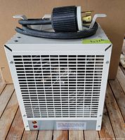 Front view showing ventilation grille, indicator lights, and caution label on heater.