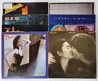 Top view of eight vinyl record album covers stacked in two rows, showing front covers of several 1980s rock and pop albums including John Lennon, Pat Benatar, REO Speedwagon, Culture Club, The Parachute Club, Bryan Adams, Dokken, and The Honeydrippers.