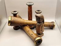 Two vintage wood carved wind instruments lying down with small First Nations wood carving figurine next to them.