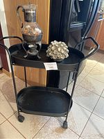 Overall set on black metal cart showing warming stand, pinecone candle holder, and cart structure