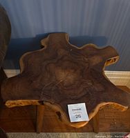 Top view showing irregular live edge natural wood slab of end table with dark brown wood grain pattern and MaxSold lot tag.
