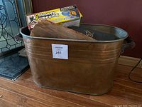 Large metal tin bucket with handles, containing a wooden matches holder and a boxed chimney sweeping log on top