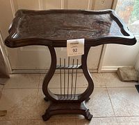 Front view of entire side table showing harp-style base and glass top