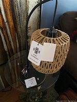 Full view of table lamp with woven shade highlighting the USB charging port tag and lamp structure.