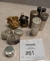 All pill boxes and hand woven brass baskets grouped together showing sizes and detail