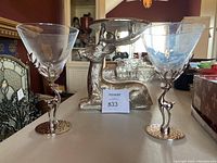 Front view showing the heavy metallic reindeer candle holder between two martini glasses with detailed reindeer stems.