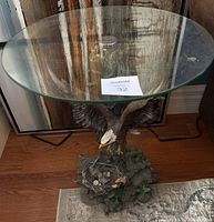Full view of the round glass top table showing eagle bird base beneath glass.