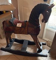 Front-side angle showing full horse with carved mane and saddle