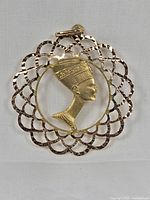 Front view of the circular filigree pendant with central profile bust of Queen Nefertiti