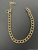 Full shot of curb link bracelet with spring-ring clasp and safety chain