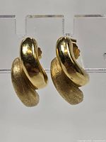 Front view of earrings showing alternating polished and matte gold curved shapes