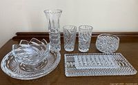 Full view of all crystal items including vase, plates, bowls and glasses arranged on wooden surface