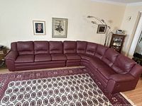 Straight-on shot of entire burgundy leather sectional modules in living room