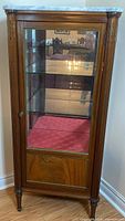 Front view of vintage Louis XVI mahogany display cabinet showing marble top and glass door.
