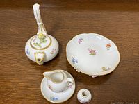 Overview of lot showing teapot, footed plate, creamer, saucer and small vase/holder