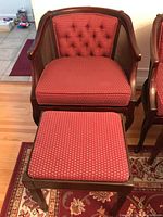 Front view of one chair and one matching stool on wood floor with rugs.