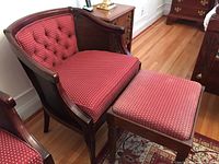 View of chair and stool set in room, showcasing upholstery and wooden frame details.