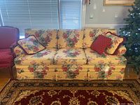 Front view of custom floral sofa with throw pillows showing overall pattern and condition