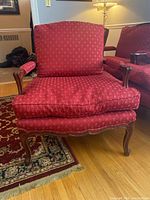 Front view of the lounge chair showing red fabric upholstery and cushioned seat and backrest.