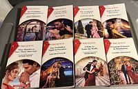 Top view of eight Harlequin Presents romance books arranged in two rows, featuring titles and cover images showing romantic poses and dramatic scenes.