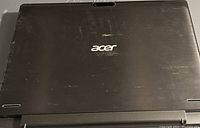 Top view of black Acer laptop with minor surface scratches