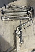 Three assorted paint rollers placed on a beige cloth background showing various paint residues and usage signs.