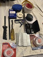 Miscellaneous hardware and crafting items including tapes, blades, tool, staple stacks and drill bits