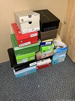 Two stacks of various shoe boxes against wall
