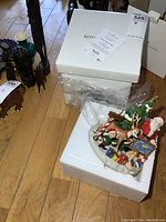 Front view of the Royal Doulton Santa's World Map figurine with box and certificate on top of a styrofoam block.