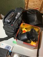 Ricoh camera and flash in yellow metal case with JVC camcorder in open shoulder bag