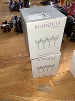Two sealed Marquis by Waterford Markham boxes stacked on wood floor