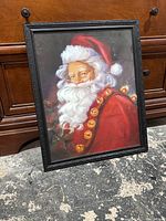 Full view of framed Santa Claus canvas with Christmas bells on red garment.