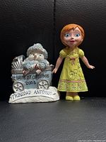 Photo showing both Christmas-themed figurines: Baby's 1st Christmas 2005 and female character.
