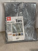 Packaged heavy duty reflective tarp with label showing size 8 ft. 6 in. x 11 ft. 4 in. and brand HFT.