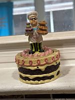 Front view of the vintage kitchen timer with chef figurine standing on cake base