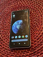 Front view of Google Pixel 2 XL smartphone showing home screen with planet earth wallpaper and app icons.