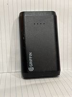 Front view of black Griffin power bank showing logo and LED battery indicator lights