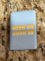 Top view of rectangular light gray power bank with yellow lettering 'DO GOOD, BE GOOD'