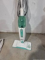 Front view of Shark steam floor cleaner showing white body with translucent green water tank and rectangular cleaning head.