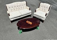 Outdoor overview of sofa, armchair and coffee table on asphalt