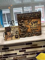 View of both wall plaques on a window ledge showing details and quotes