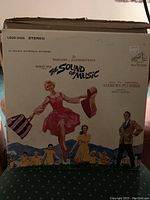 Front cover of The Sound of Music soundtrack LP record in original sleeve showing illustrated dancing woman and title text.