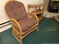 Large bamboo framed chair with brown cushioned seat and back, visible lattice design on frame, shown angled in room.